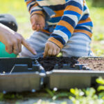 small boy helping his mother do the planting