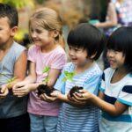 group of diverse kids holding plants